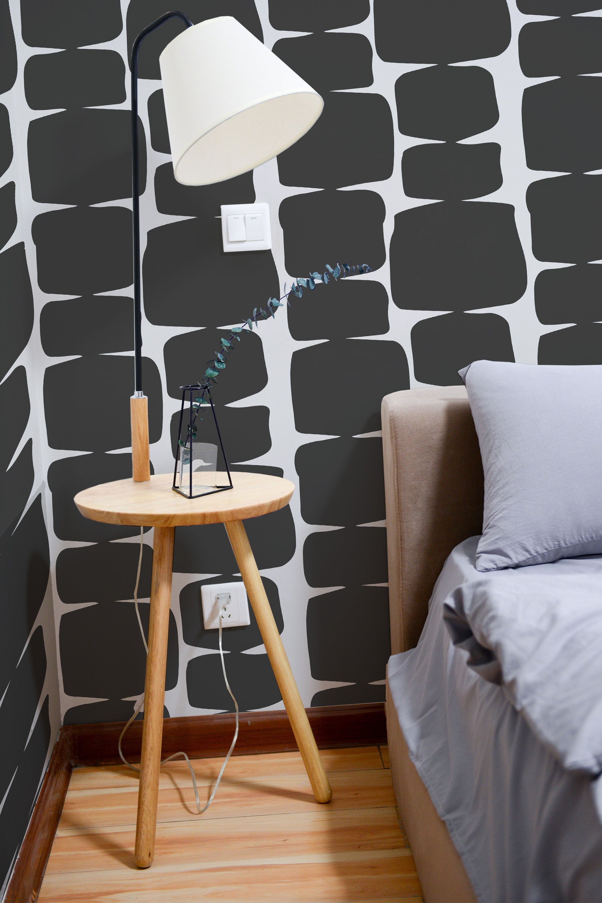 Self-adhesive wallpaper with a black retro shape design, featuring bold, organic patterns reminiscent of mid-century modern aesthetics. The graphic shapes create a striking contrast against the light-colored background, adding depth and visual interest to the space.