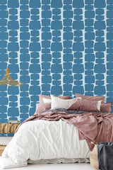 Abstract geometric shapes in a bold blue color repeat in a grid-like pattern over a white backdrop, creating a mid-century modern aesthetic. The arrangement adds a striking yet harmonious balance to the room's decor. Traditional wallpaper.
