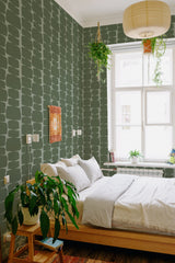 A room with green retro-shaped wallpaper in a repeating pattern of abstract, rounded rectangles in various shades of green. The wallpaper adds a vintage and stylish ambiance to the room. Traditional wallpaper.