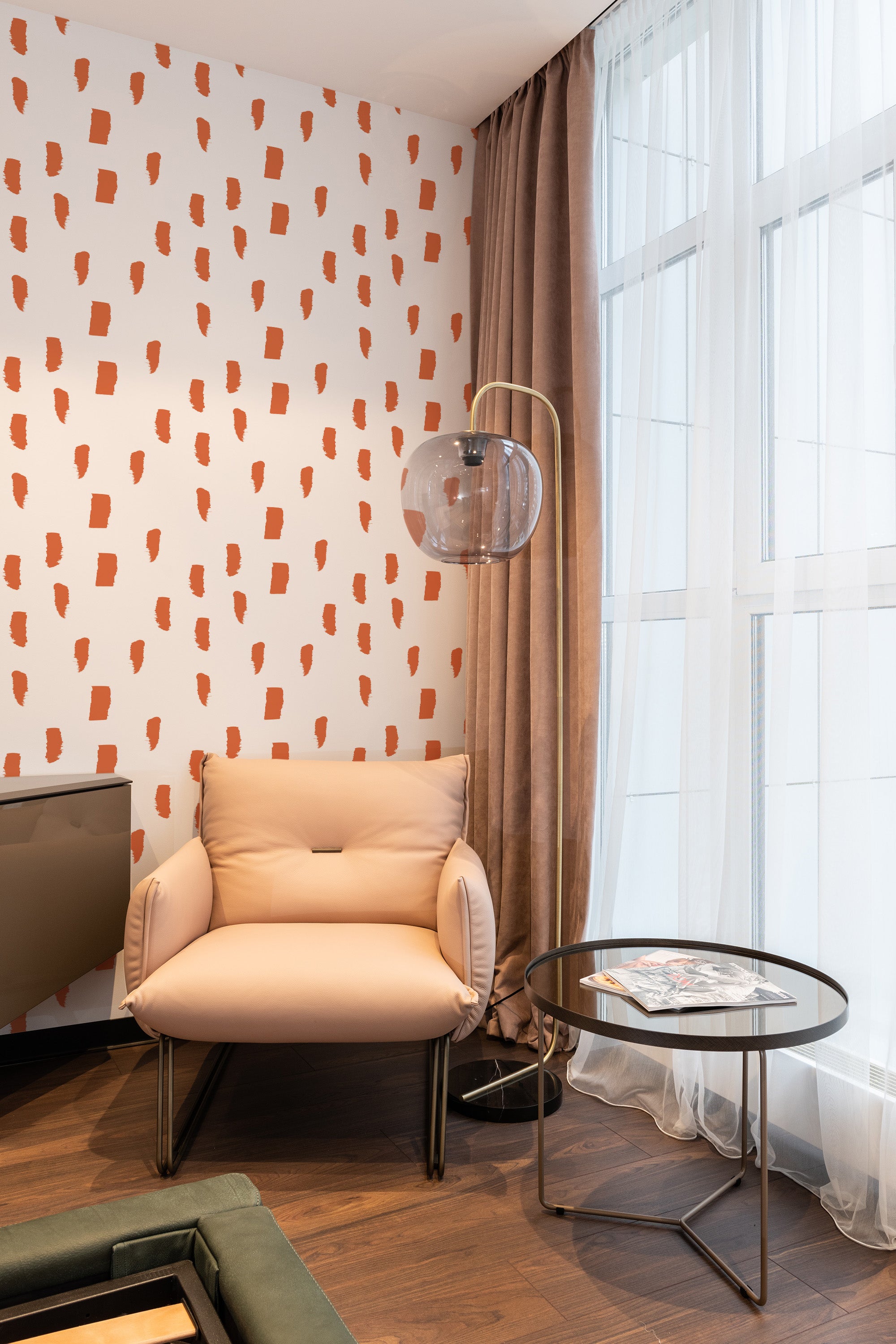 A wall covered in a painted dots print wallpaper with irregular, abstract orange shapes on a white background, creating a modern yet traditional wallpaper.