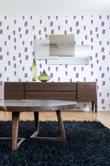 A room with wallpaper that has a hand-painted dots design in a scattered pattern with purple brushstroke-like shapes on a white background. Traditional wallpaper.