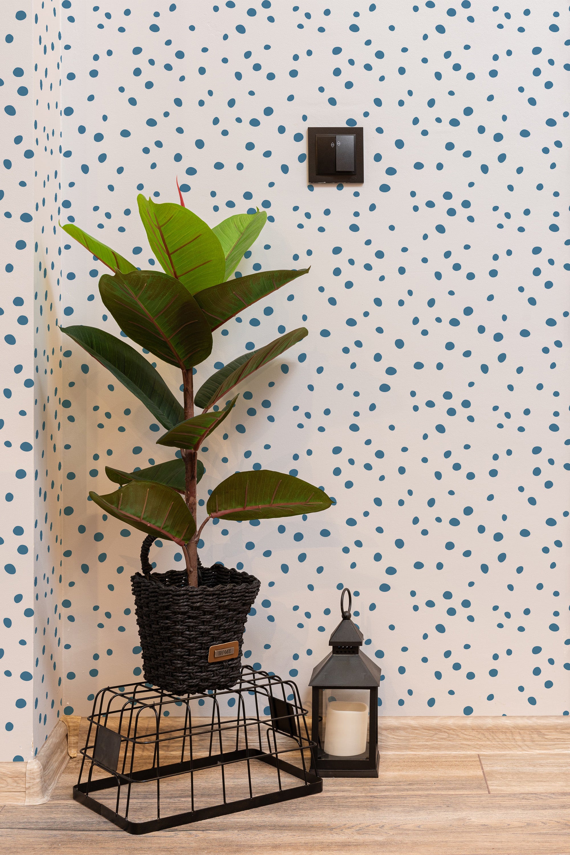 Self-adhesive wallpaper with a white background and small, randomly spaced blue dots, adding a subtle and playful pattern to the room.