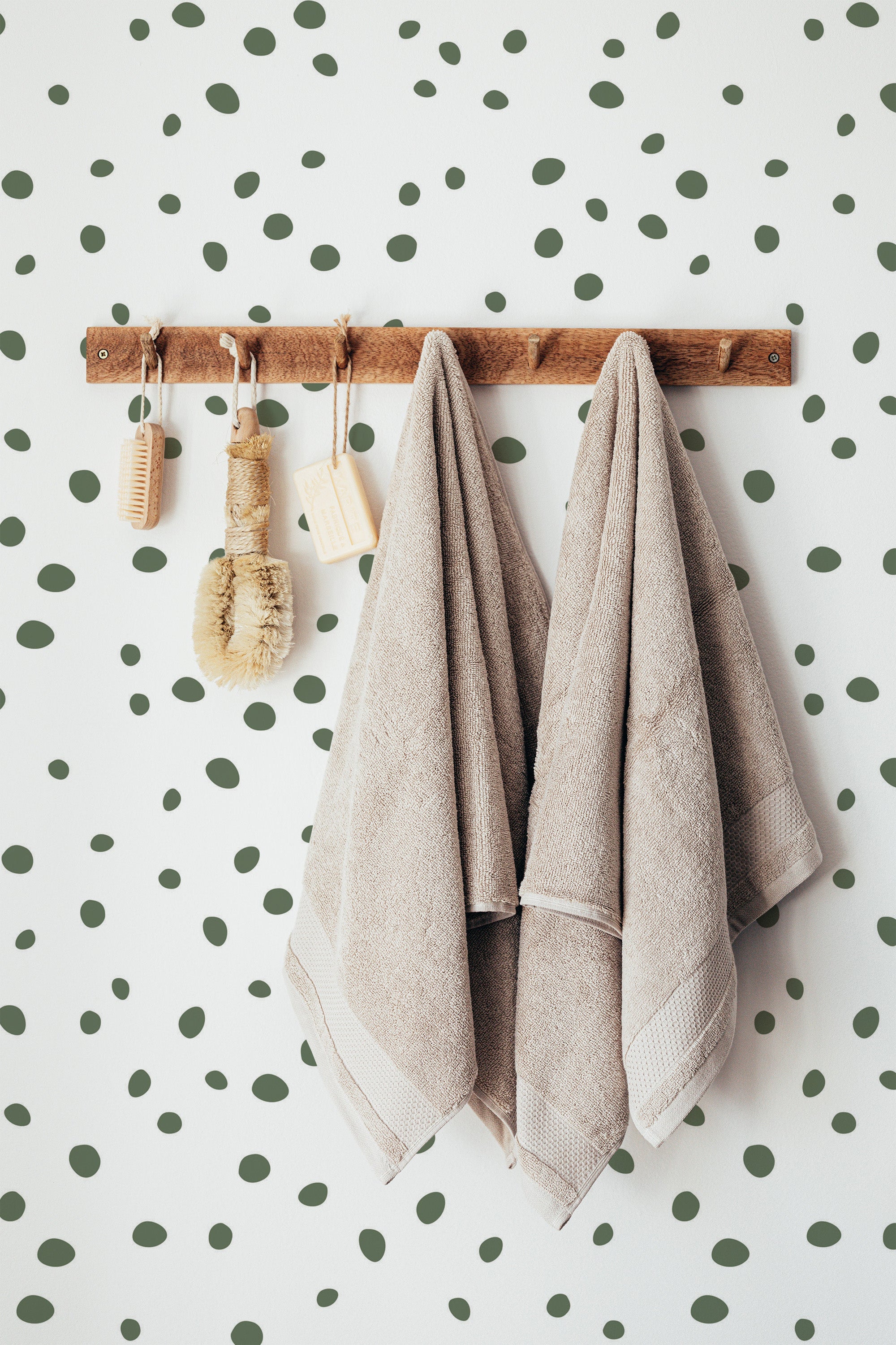 Self-adhesive wallpaper with a Green Dalmatian design, characterized by randomly spaced olive-green spots on a white background.