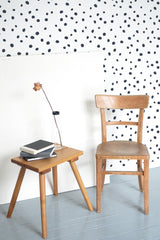 Self-adhesive Dalmatian wallpaper with a white background and irregular black dots creating a playful and modern pattern.