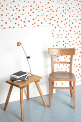 Self-adhesive wallpaper with a pattern of small orange spots scattered evenly across a white background, creating a lively and playful atmosphere in the room.
