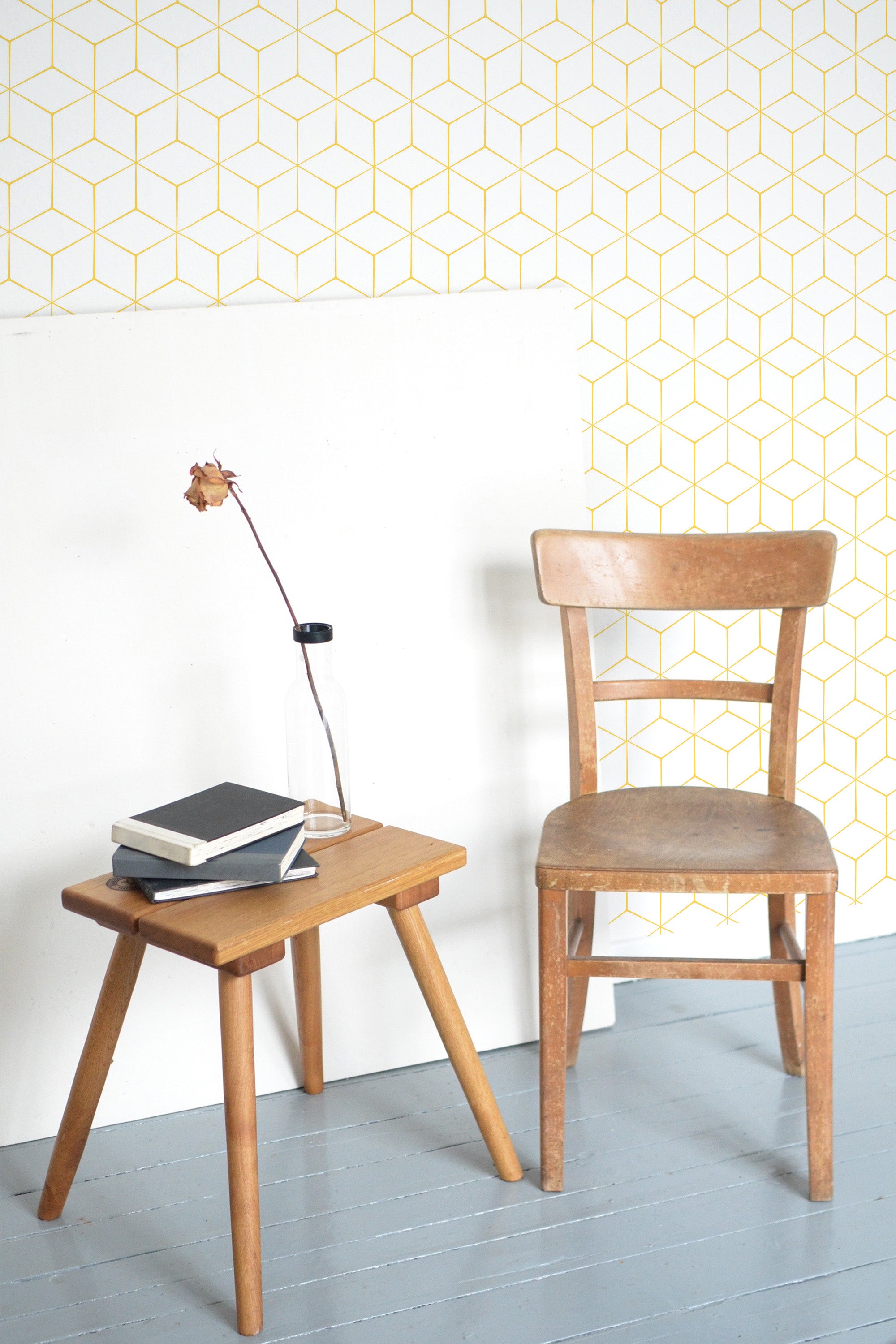 Self-adhesive wallpaper with a geometric pattern of yellow lines forming interconnected cubes on a light background.
