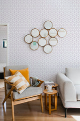 Wallpaper with a pattern of interlocking hexagonal shapes in a subtle, muted color palette, complementing the modern decor of the room. Traditional wallpaper.