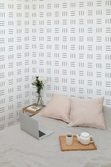 Self-adhesive wallpaper with a minimal geometric lines pattern in black arranged in a grid on a white background, creating a modern, clean aesthetic.