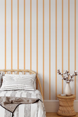 Self-adhesive wallpaper with vertical orange stripes on a white background.