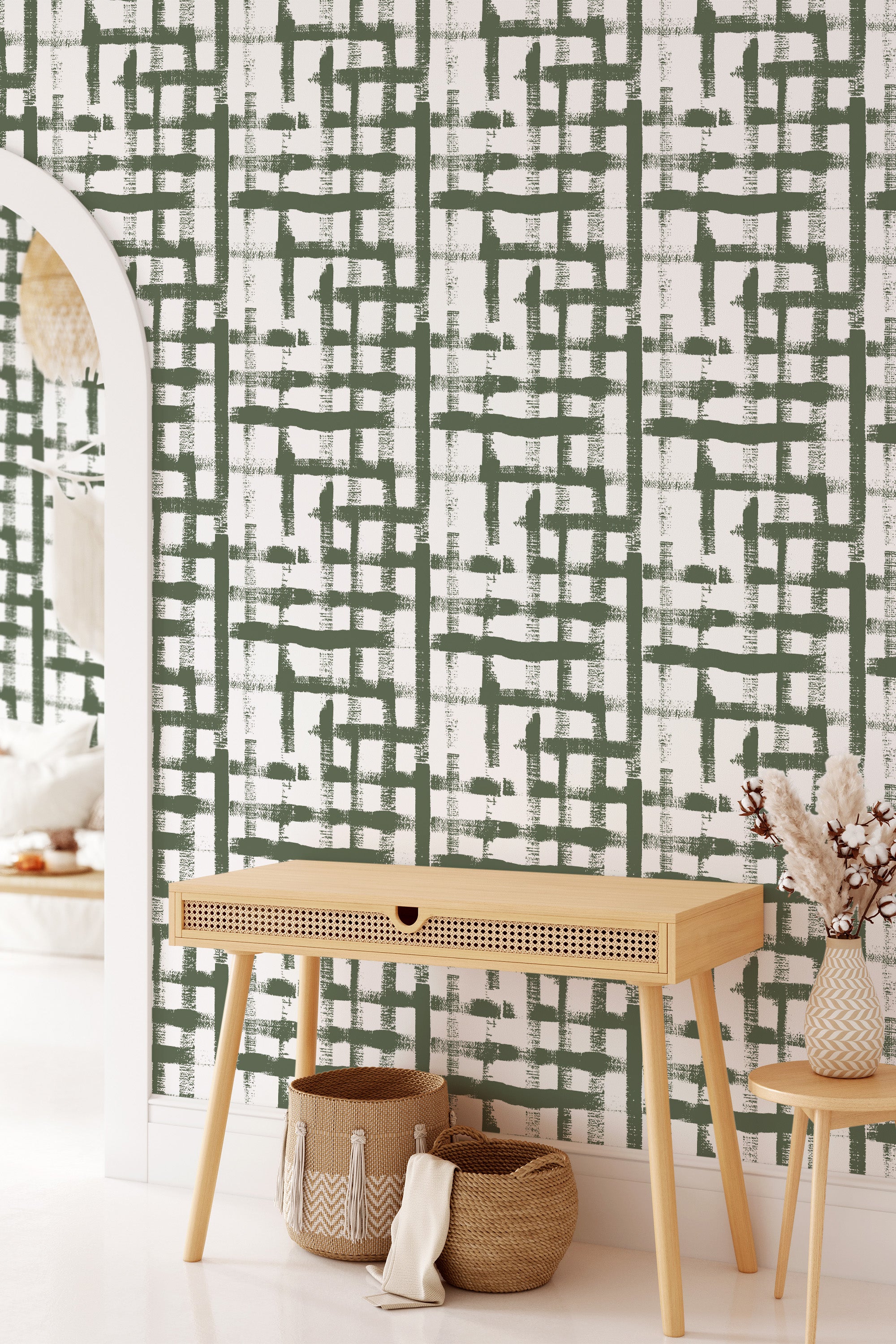 A room with green brushstroke pattern forming an abstract, imperfect grid on the wall, creating a textured and artistic effect. Complemented by a light, minimalist console table with woven baskets beneath, the wallpaper adds a modern twist to traditional wallpaper.