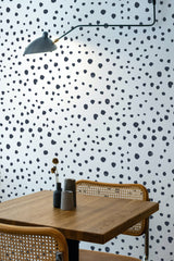 Self-adhesive Dalmatian print wallpaper with irregular black spots scattered across a white background, creating a playful and modern look.