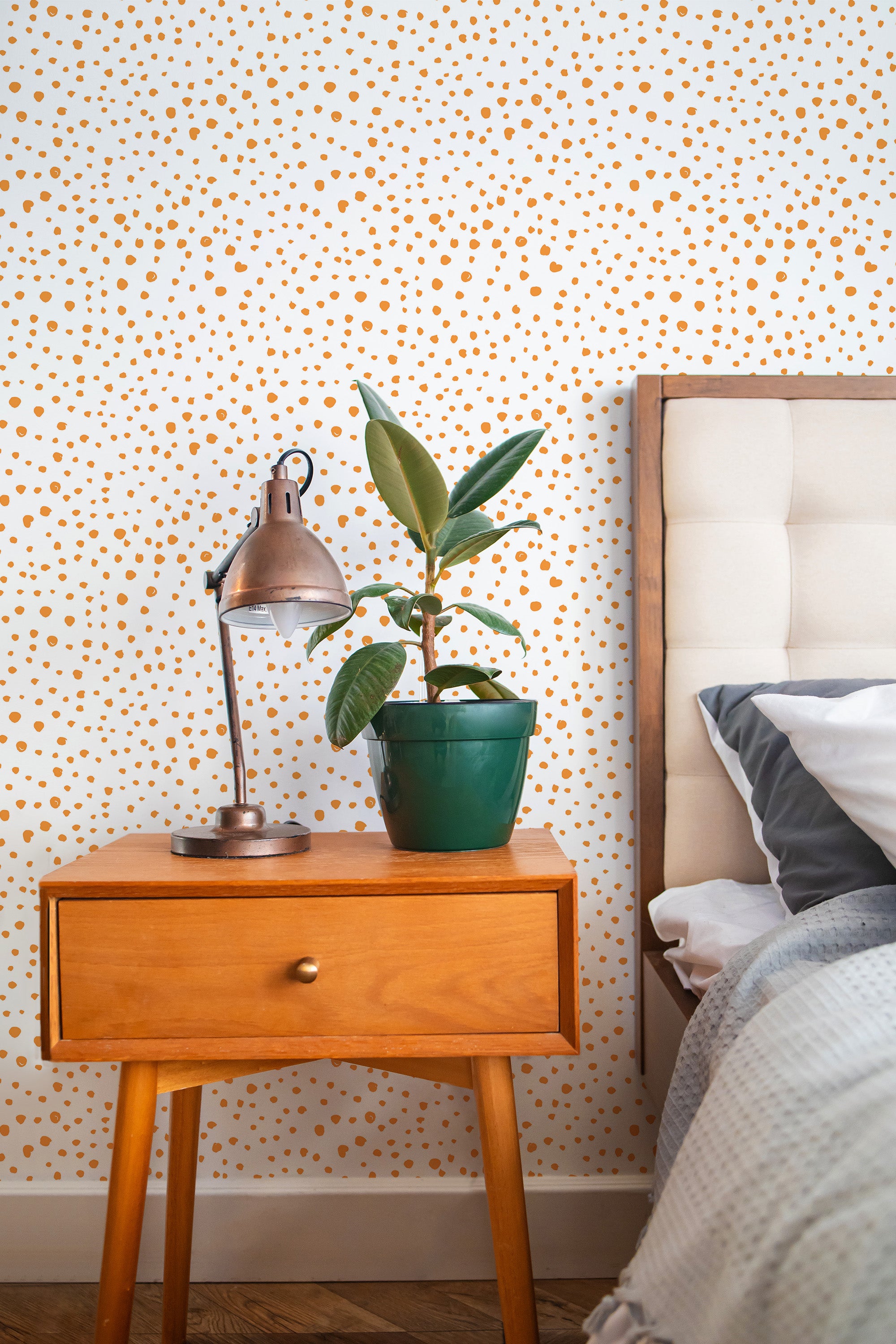 Self-adhesive dotted wallpaper in a room with a cream background and orange irregularly spaced dots.