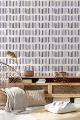 The wallpaper design has a repeating pattern of vertical brushstroke lines in varying shades of blue and gray, forming an abstract and modern look on a white background, traditional wallpaper.