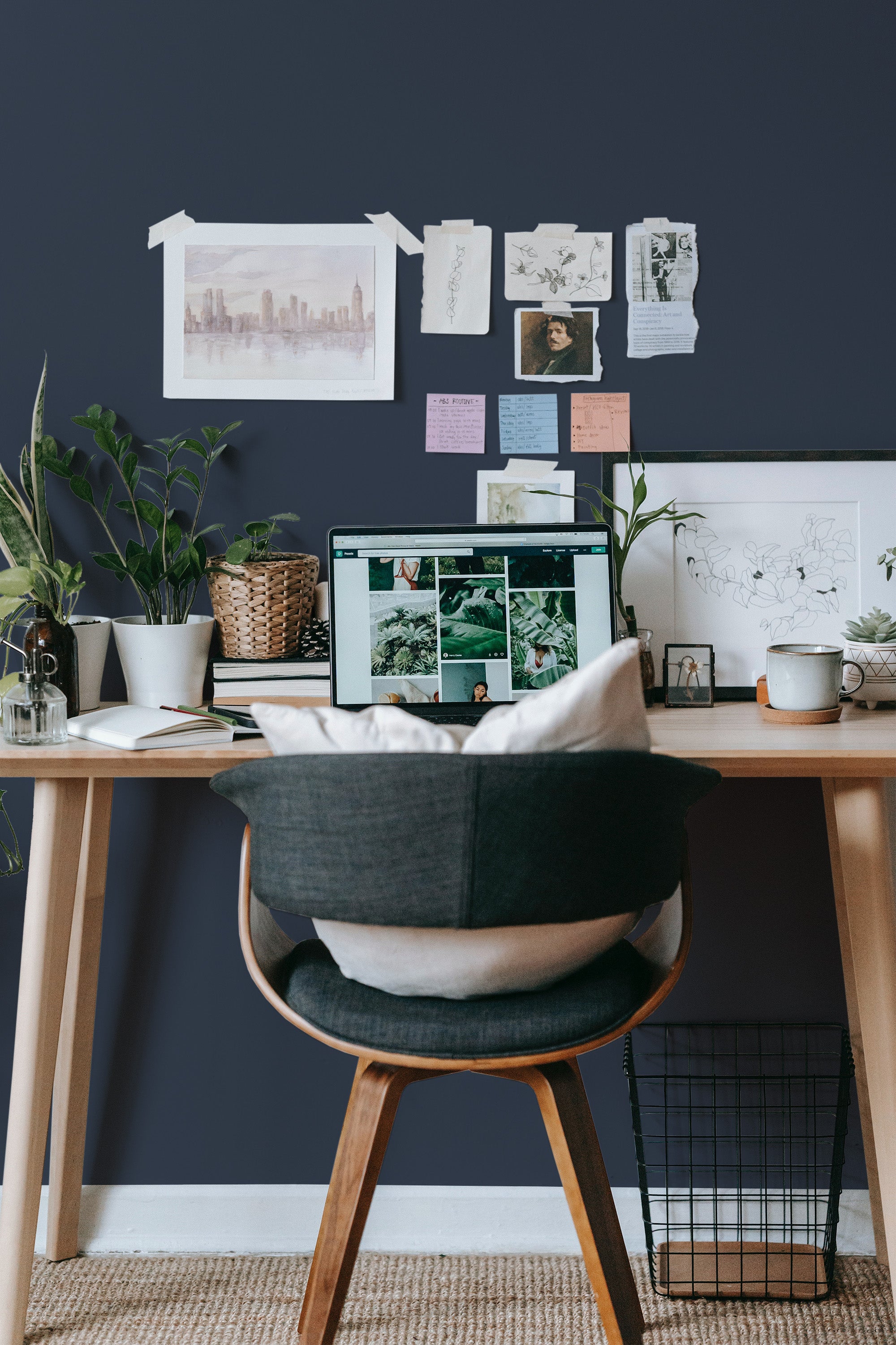 Self-adhesive solid color wallpaper in a deep navy blue adorning a cozy workspace, complementing the natural wood desk and neutral decor elements in the room.