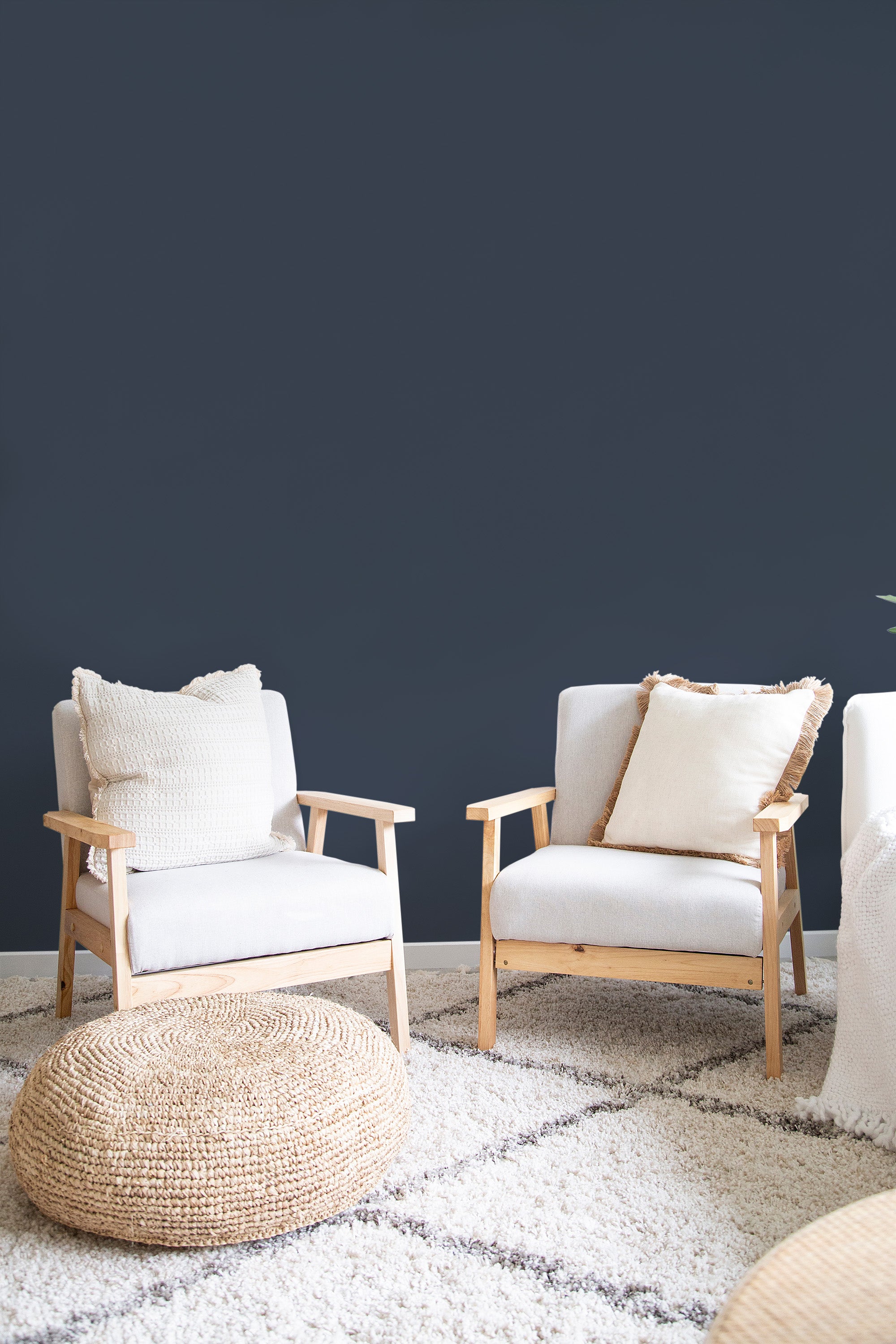 A room with dark navy blue solid color wallpaper paired with light wooden furniture and neutral decor, creating a classic and traditional wallpaper.