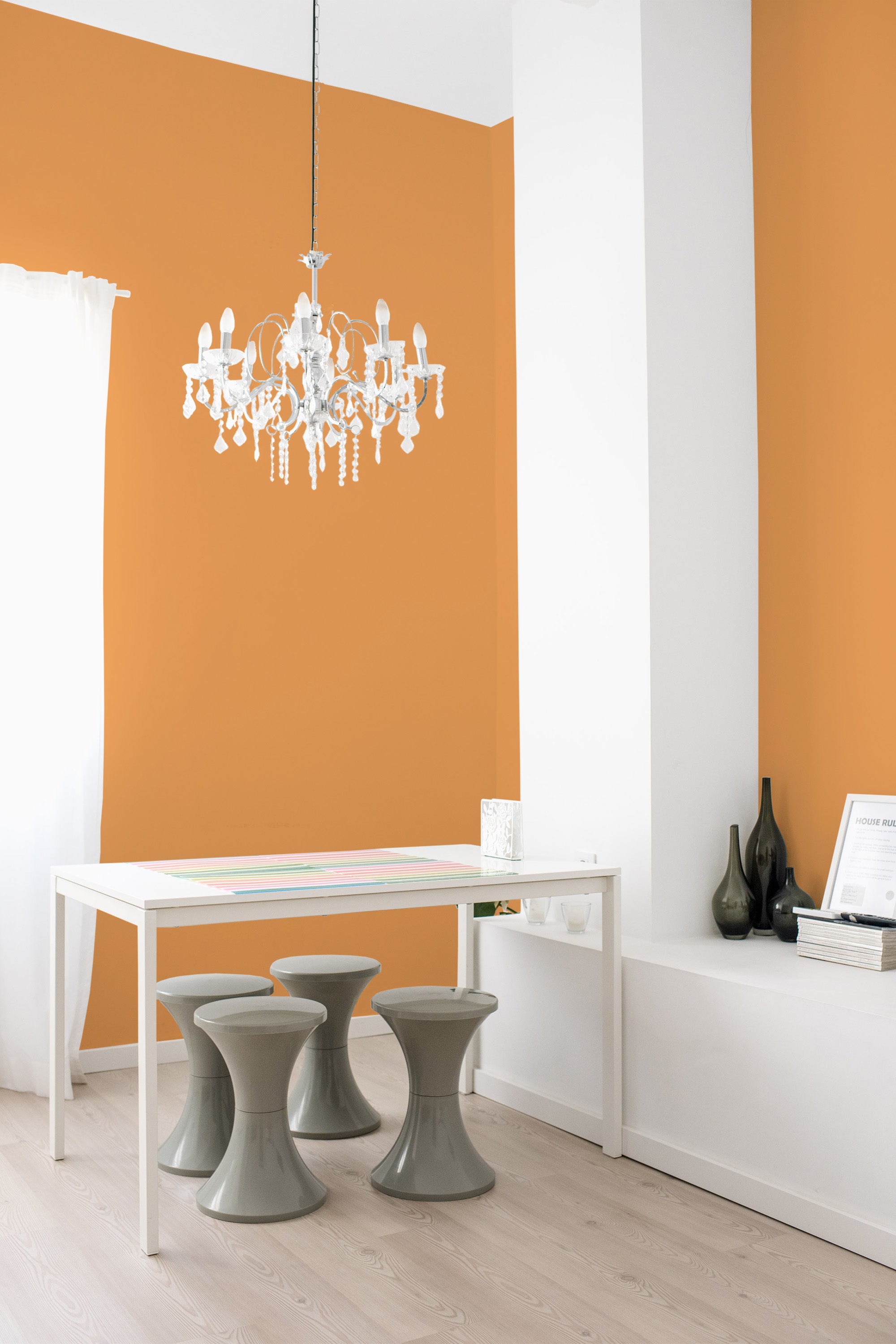 The room has orange plain design wallpaper with a smooth, solid finish, adding warmth and elegance to the space. The wallpaper complements the minimalist decor and white trim, creating a cozy and inviting atmosphere. The room���s simple and clean-lined furniture enhances the overall aesthetic, emphasizing the traditional wallpaper.