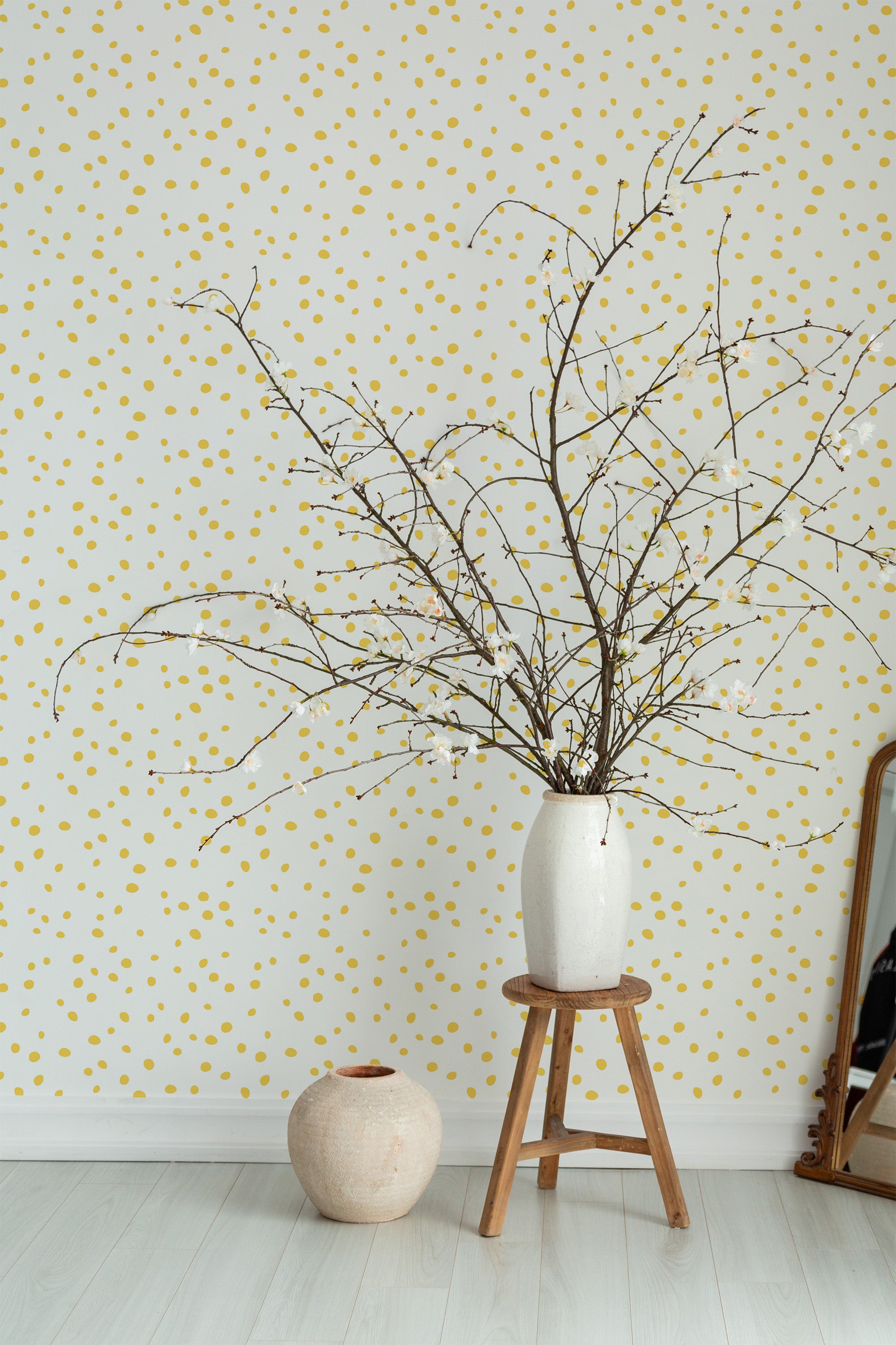 Self-adhesive Dalmatian wallpaper with small, irregular gold and yellow polka dots on a white background, adding a playful yet elegant touch to the room decor.