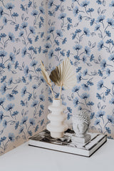 Self-adhesive wallpaper with a Bluebottle design of delicate blue flowers and leafy branches on a white background, creating a soft and serene floral pattern.