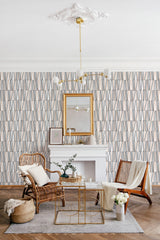 Line art design wallpaper with vertical linear patterns in muted tones of blue and beige, adding a modern yet subtle aesthetic to a cozy, traditionally furnished room with rattan seating. Traditional wallpaper.