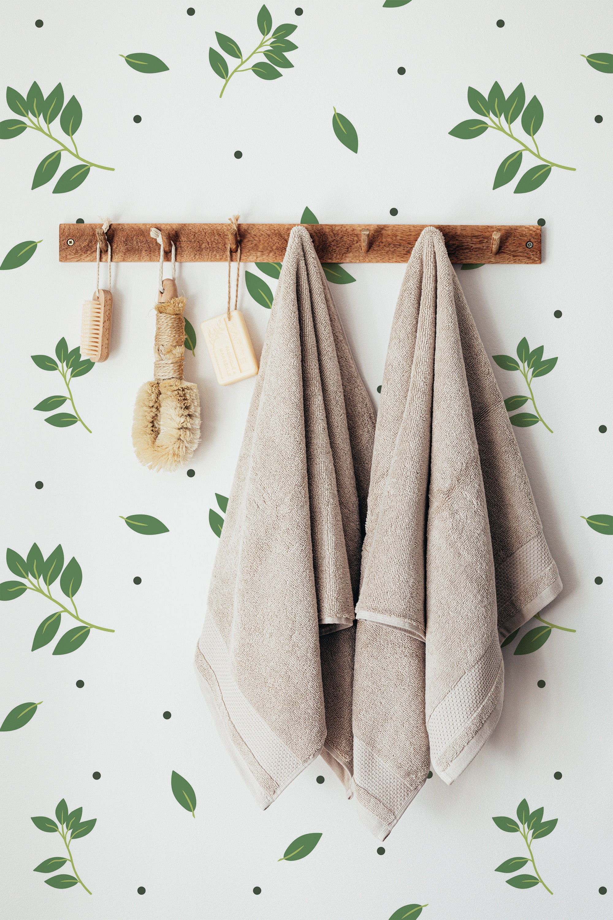 Self-adhesive wallpaper on a wall with a Leaf dots design, combining green leaves and small black dots on a white background for a natural, minimalist look.