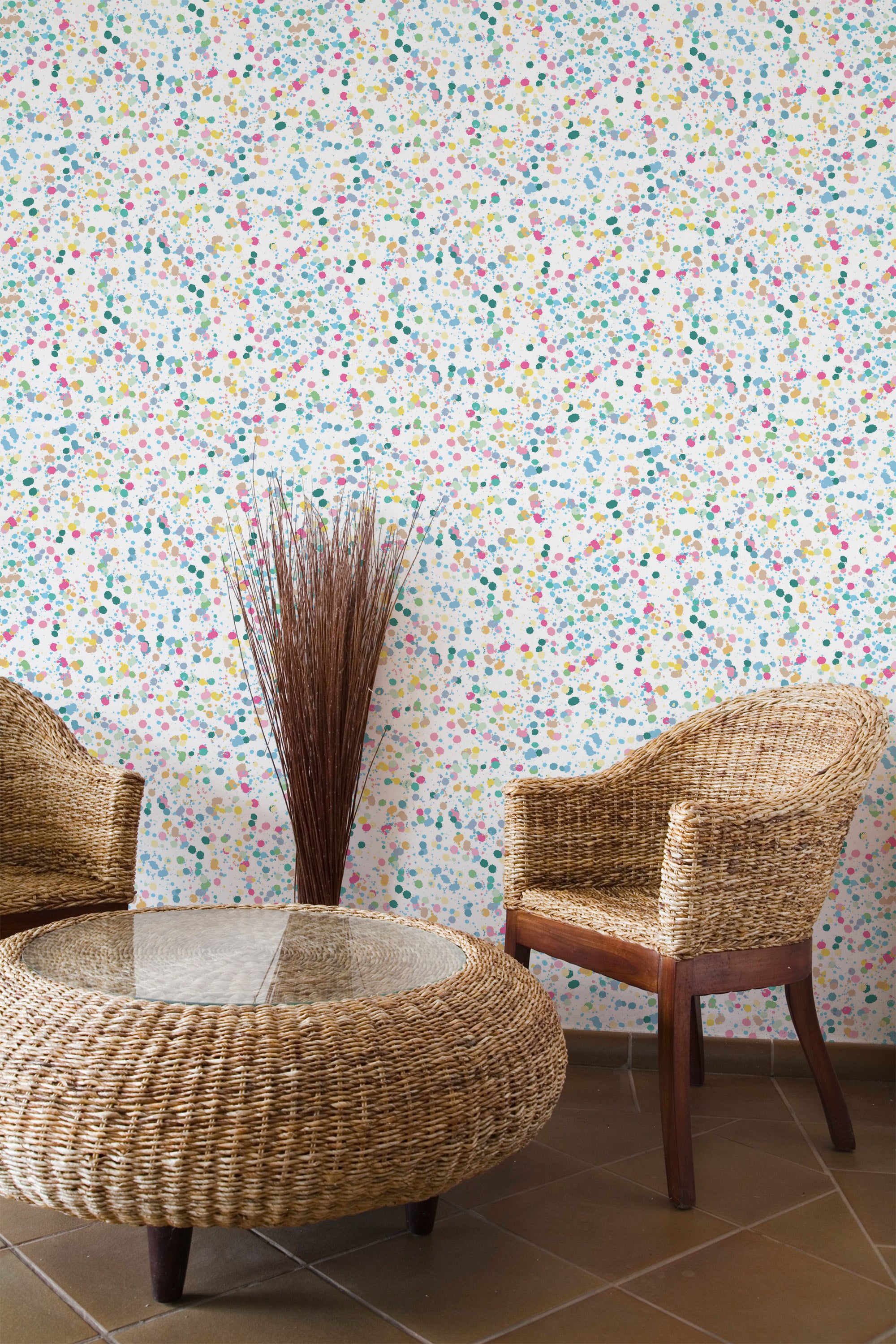 Self-adhesive wallpaper with a multicolored abstract pattern of tiny, irregular ink-like splatters in shades of blue, pink, green, and yellow on a white background, adding vibrant texture to the room.