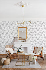 Room with wallpaper covered in a minimal floral design of simple, outlined leaves distributed evenly on a light-colored background, creating a subtle yet elegant look that complements the room's furnishings and traditional wallpaper.