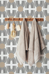 Self-adhesive Boho wallpaper with a geometric pattern of black arches and tan circles on a white background, creating a modern and earthy aesthetic.