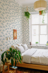 The wallpaper in the room has a repeating pattern of abstract leaf motifs in soft blue tones on a white background, creating a serene and natural ambiance with a hint of modernity, characteristic of traditional wallpaper.