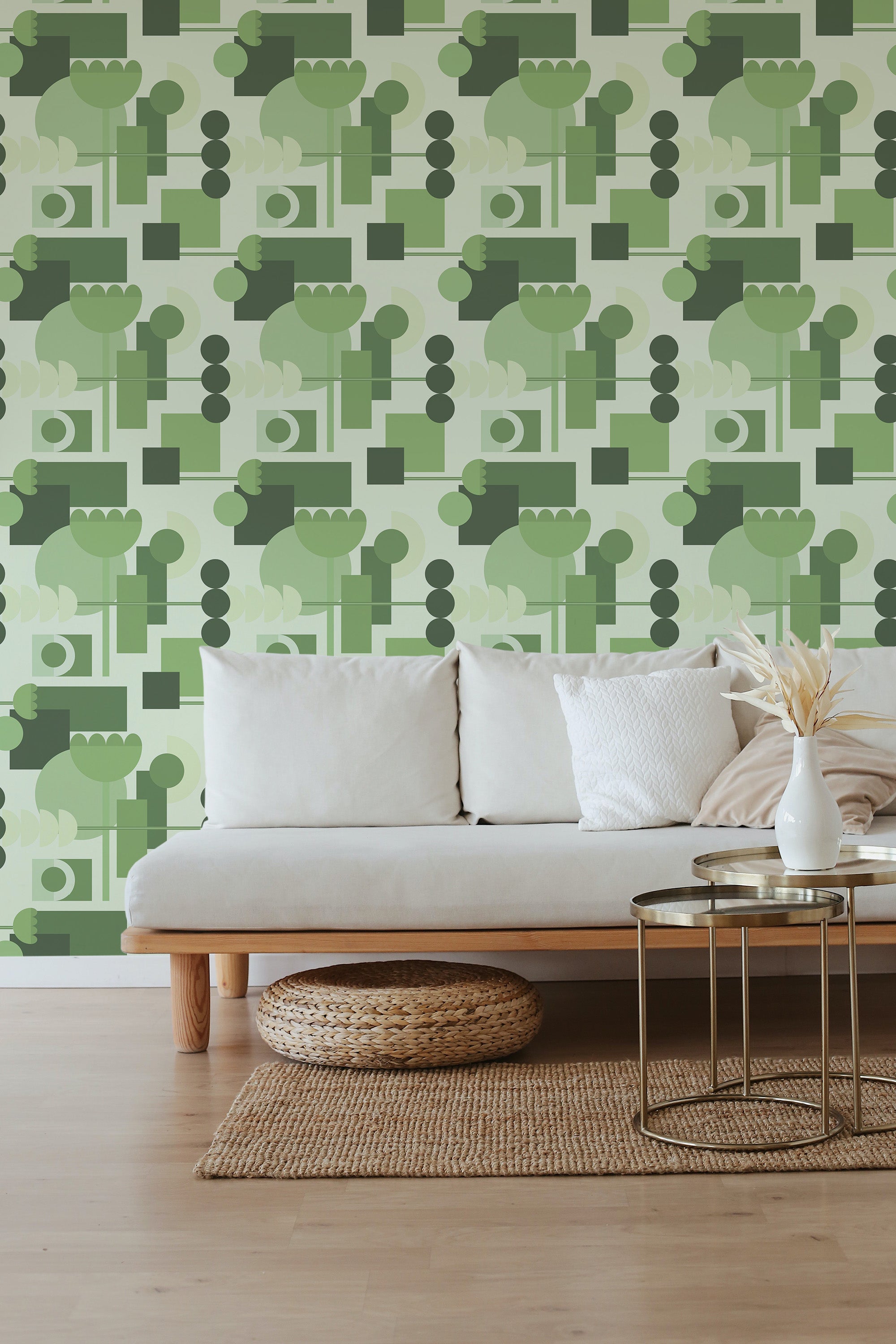 A living room with green mid-century wallpaper featuring abstract geometric shapes, including trees, leaves, and circles, in varying shades of green on a light background. Traditional wallpaper.