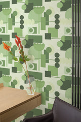Self-adhesive wallpaper with a Green mid-century design, highlighting geometric shapes and abstract forms in various shades of green. The pattern arranges circles, rectangles, and stylized flower motifs, creating a playful yet sophisticated look.