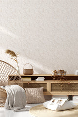 A wall adorned with a subtle, intricate floral pattern in soft, neutral tones, creating a serene and elegant atmosphere in the room. The design incorporates delicate leaves and flowers, adding a classic and timeless touch to the living space. Traditional wallpaper.