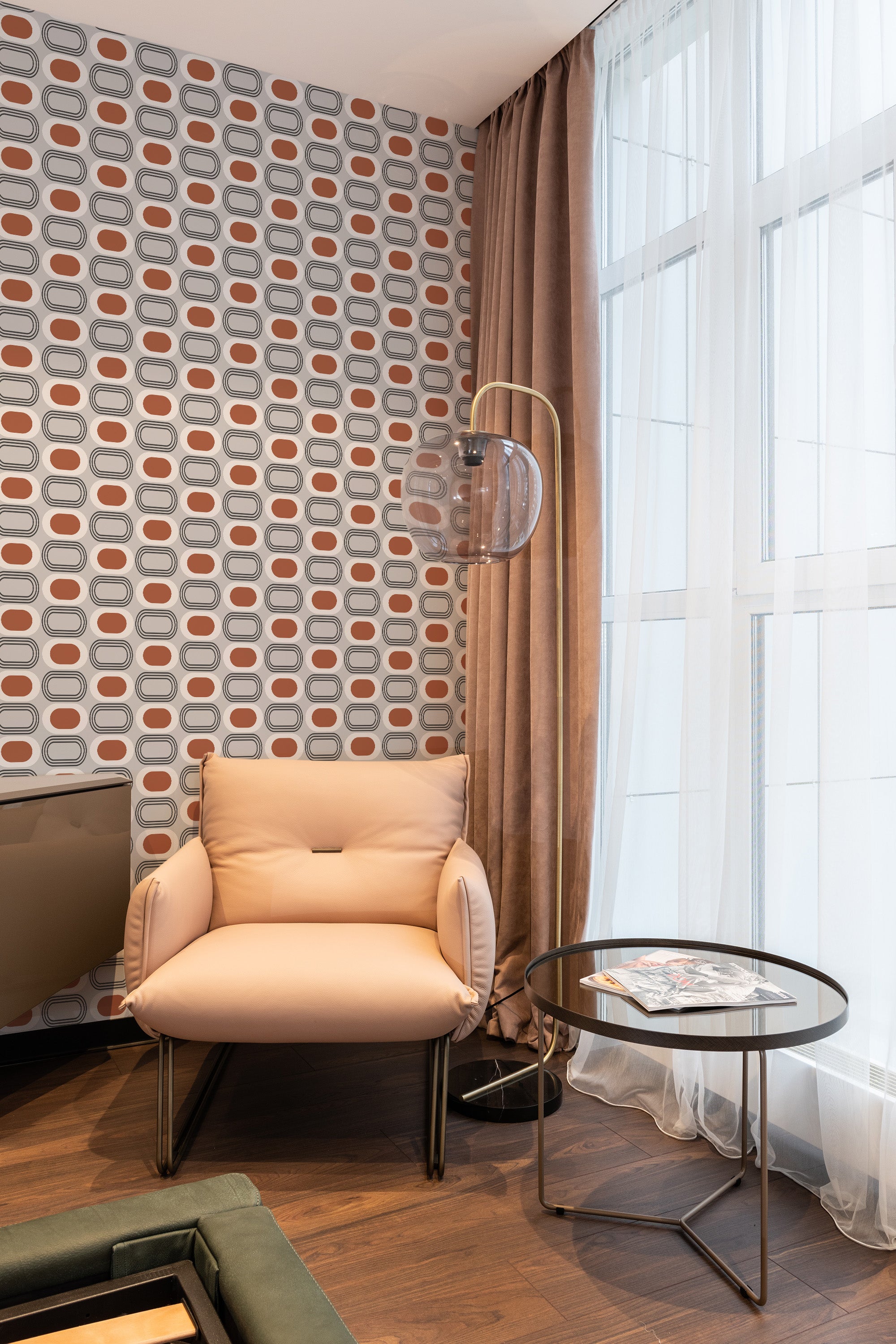 Mid-century geometric wallpaper with a repeating pattern of elongated ovals in shades of beige, brown, gray, and white, creating a visually striking retro vibe. Traditional wallpaper.