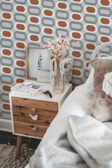 Self-adhesive Mid-century geometric wallpaper with a pattern of alternating orange ovals and gray arches on a white background.