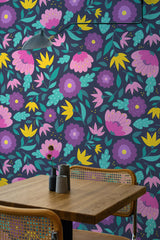 Self-adhesive dark floral wallpaper with vibrant purple, pink, and yellow flowers interwoven with green leaves on a deep, almost-black background. This bold and lively design adds a striking touch to the room, creating a modern and cozy atmosphere.
