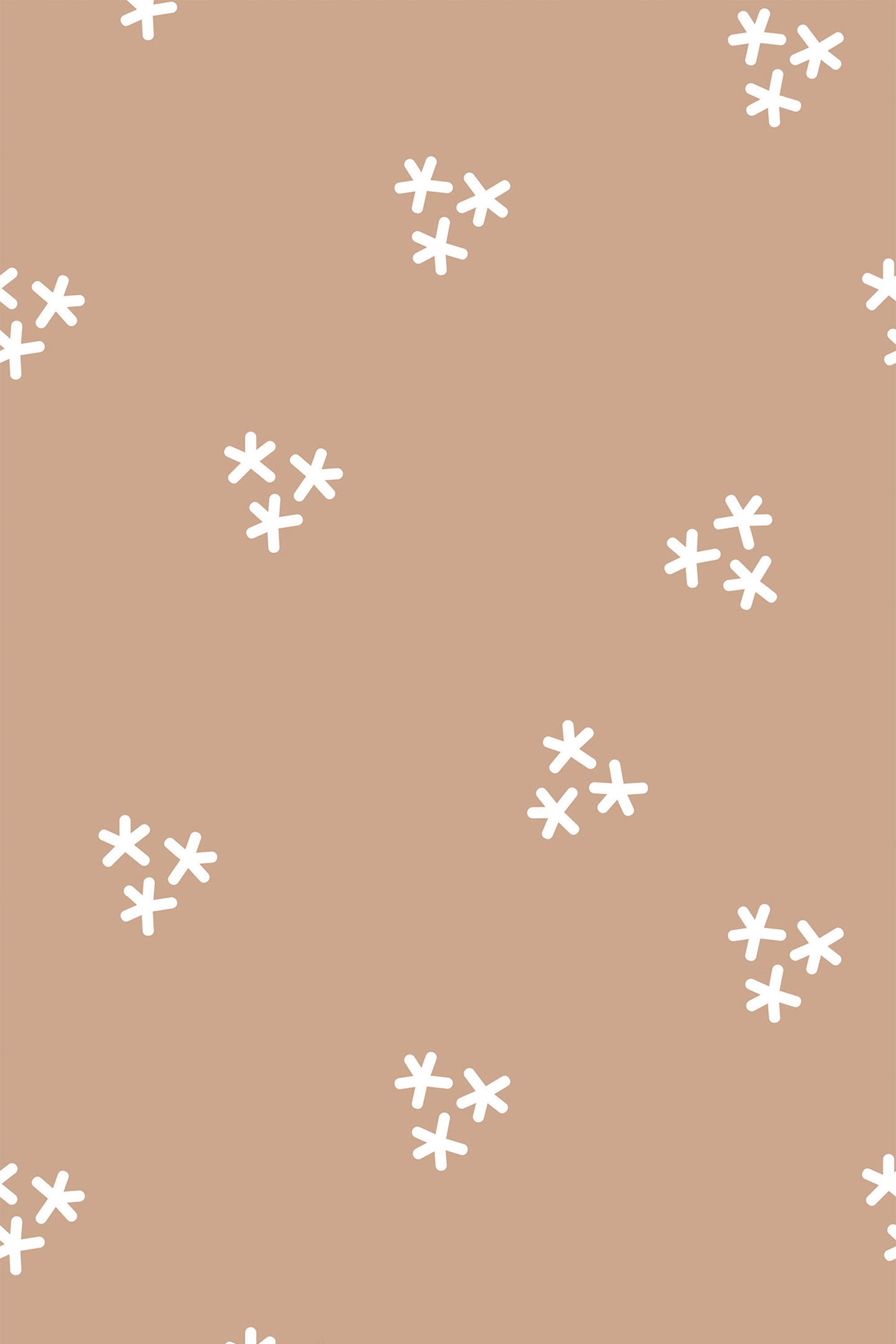 Small white, simple floral patterns scattered evenly across a warm, light brown or tan background. The design is minimalist, with the flowers consisting of five petals each, arranged in clusters with space between them. Peel and stick removable wallpaper.
