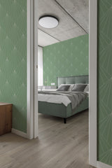 Bold Art Deco wallpaper with a geometric pattern of silver lines forming fan-shaped designs on a soft green background in a bedroom with light wood flooring. Traditional wallpaper.