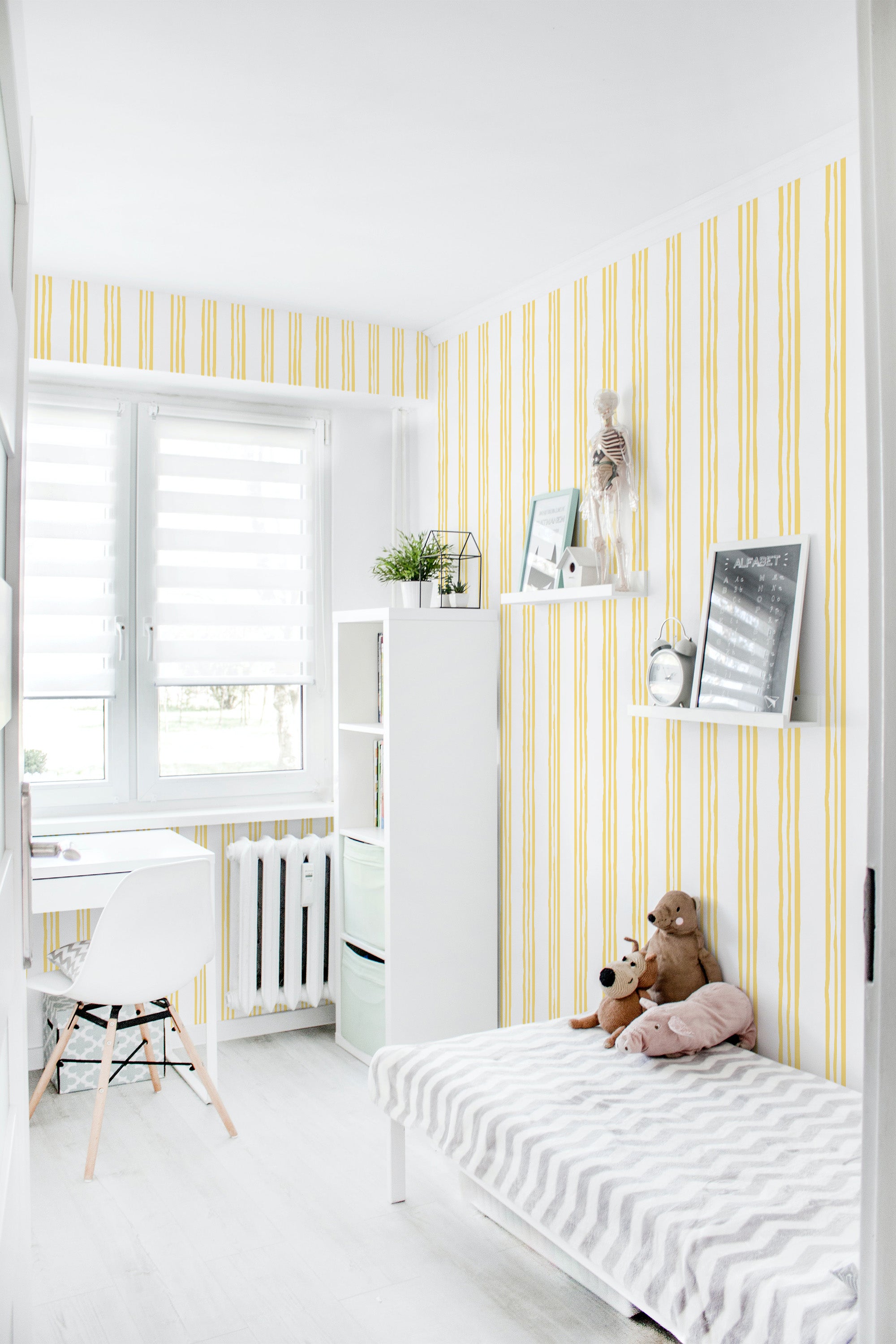 Wallpaper with a design of vertical yellow stripes arranged irregularly on a white background. The unevenly spaced stripes give a lively and playful feel, while the soft colors blend well with the light interior. A perfect choice for adding character to a room while maintaining the charm of traditional wallpaper.