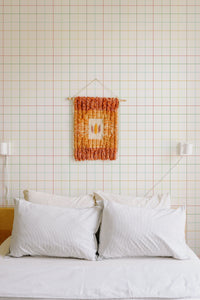 Self-adhesive wallpaper with a minimalist grid pattern of thin, colorful lines creating a simple, clean, and modern geometric design on a light background.