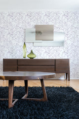 A room with wallpaper covering the wall in a large, intricate floral pattern with delicate, naturalistic outlines of leaves and branches, giving the space a classic and elegant look. Traditional wallpaper.