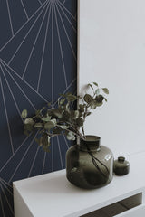 Self-adhesive art Deco wallpaper with a dark backdrop and light geometric lines forming a fan-like pattern for a stylish and modern look.