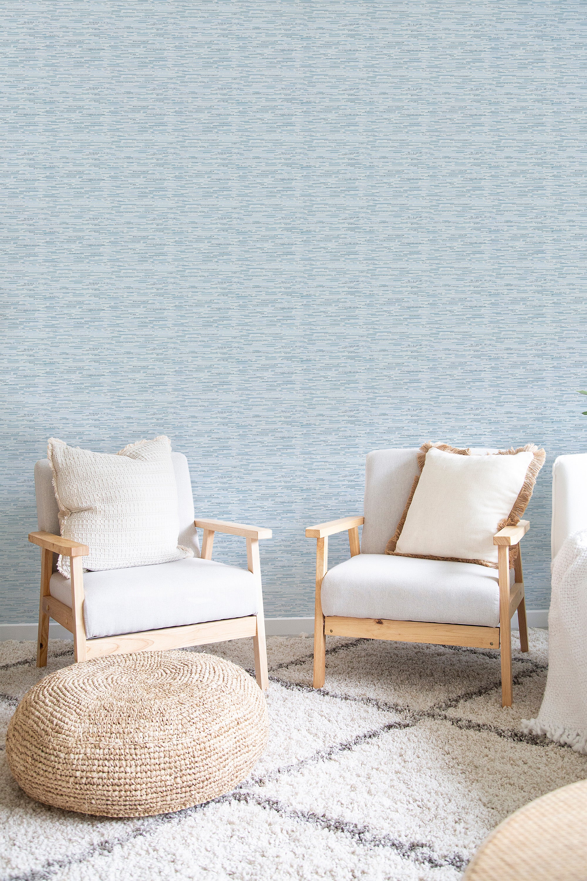 A room with a soft blue and beige Grasscloth wallpaper that creates a textured, woven effect, complementing the natural, minimalist decor. Traditional wallpaper.