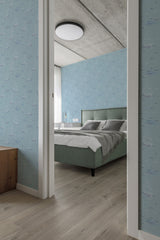A bedroom with wallpaper showing light blue shades and artistic waves, sailboats, and seagulls scattered throughout the pattern. The restful, nautical motif contributes to a serene atmosphere in the room. Traditional wallpaper.