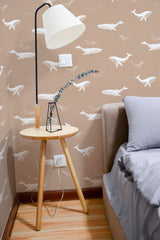 Self-adhesive wallpaper with whimsical white whale illustrations swimming on a soft beige background, adding a playful yet serene touch to the bedroom.