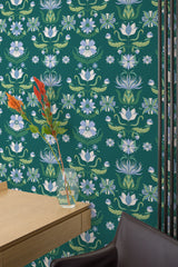 Self-adhesive bold art nouveau wallpaper with a rich green background, adorned with intricate floral patterns in soft blue, white, and green tones. The flowers are stylized with flowing lines, creating a harmonious and elegant vintage look.