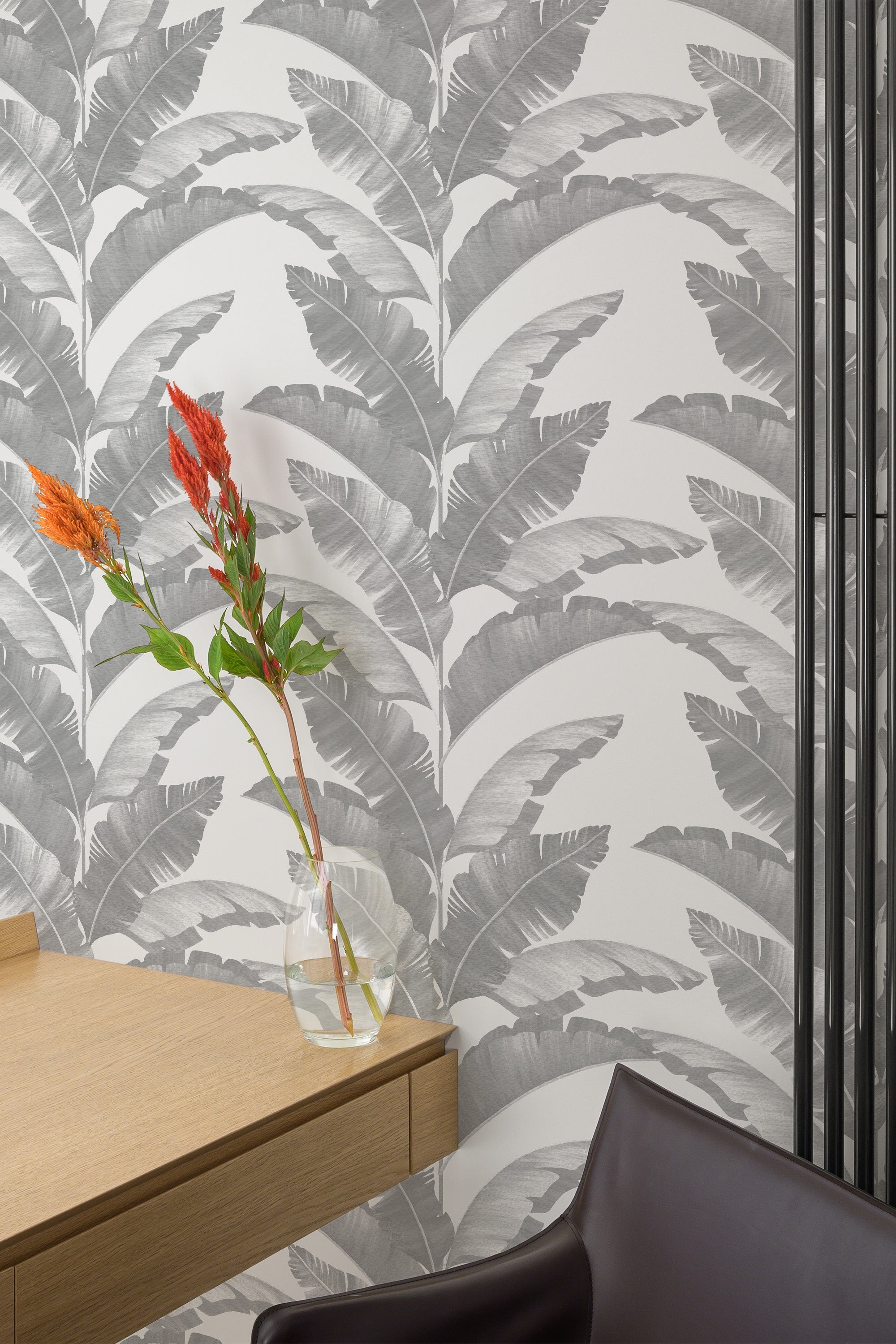 Self-adhesive wallpaper with a gray tropical leaves pattern, creating a calming and natural atmosphere in the room.