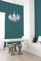 The wallpaper design is a rich teal hue adorned with scattered circular patterns, creating a modern yet classic aesthetic. The intricate design adds textured depth to the walls of the room, balancing contemporary style with a nod to traditional wallpaper.