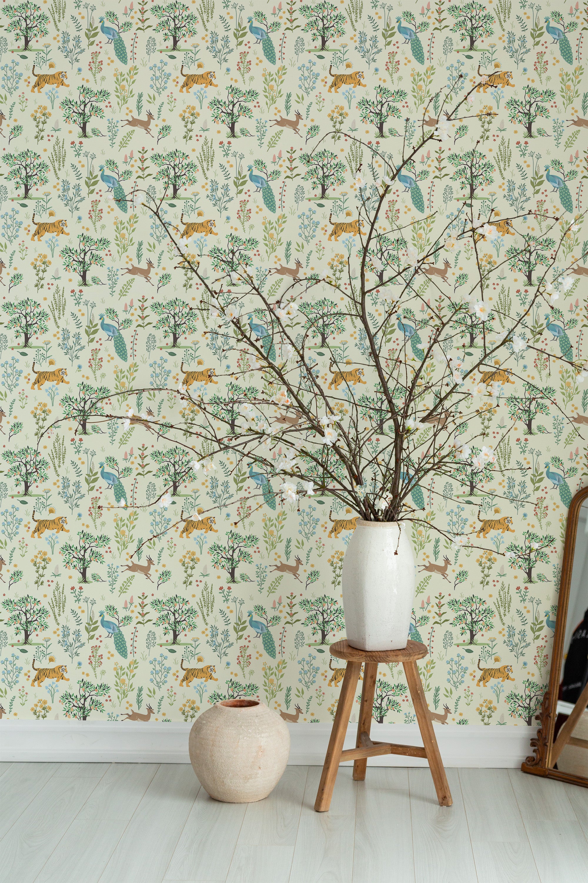 Self-adhesive wallpaper with a Menagerie design of playful leopard silhouettes among whimsical trees and leafy foliage, in soft greens, blues, and yellows on a light cream background.