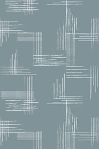 A minimalist brush tile pattern with intersecting, unevenly spaced white brush strokes on a muted blue-gray background. Peel and stick removable wallpaper.