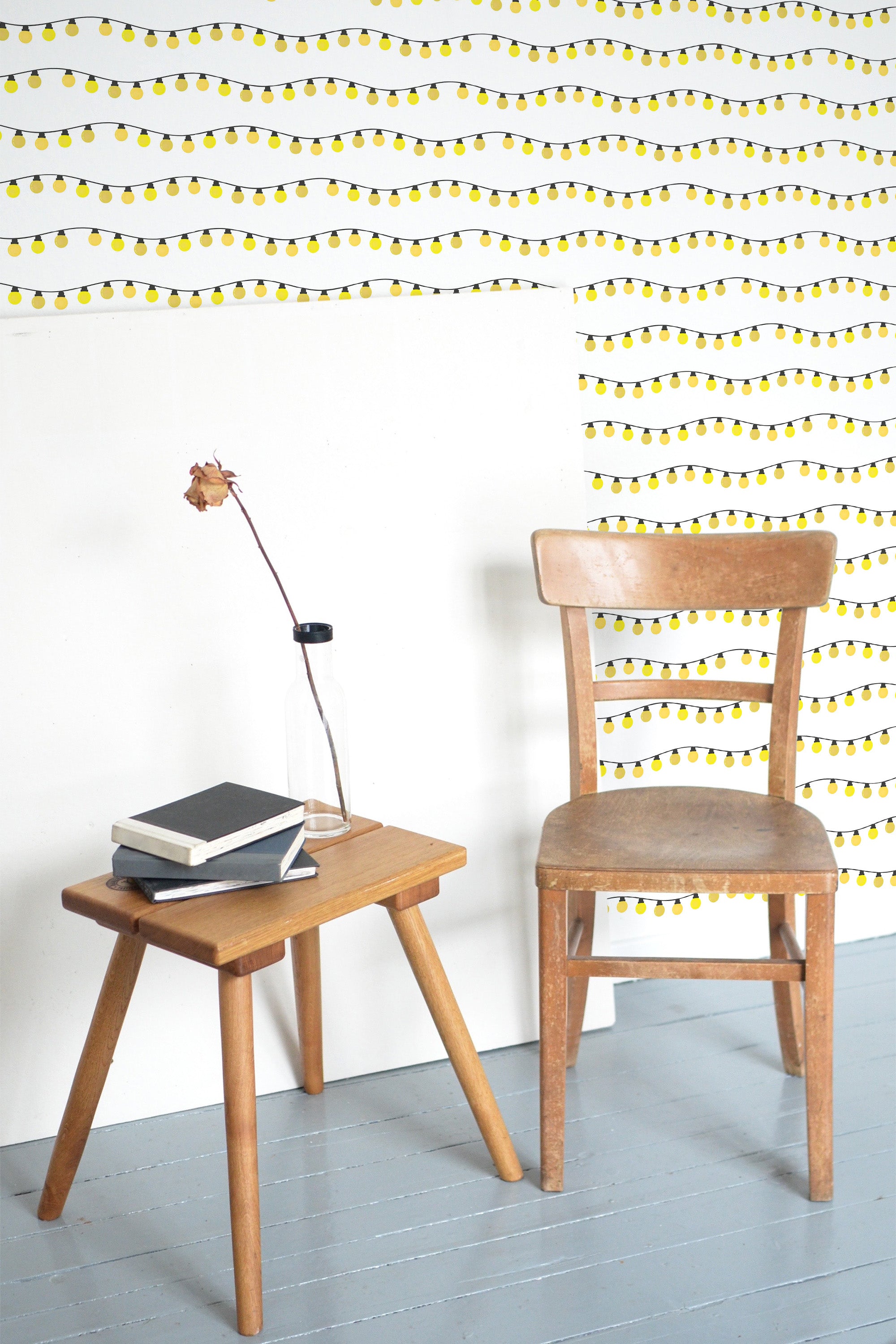 Self-adhesive wallpaper with a festive design of yellow Christmas lights strung in a wavy pattern across a white background.