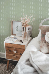 Self-adhesive wallpaper with a sage green background and simple, white vertical brush stroke patterns.